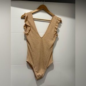 Body suit with ruffle detail. NWT.